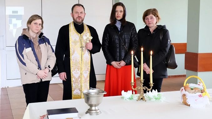 Grupa osób z księdzem prawosławnym