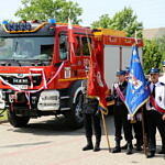 Nowy samochód ratowniczo-gaśniczy i strażacy ze sztandarami
