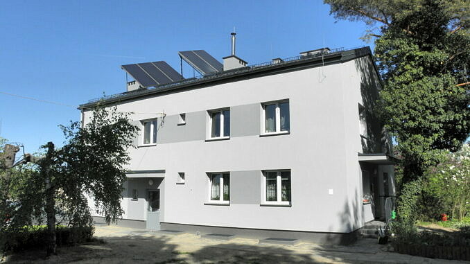 Wyremontowany budynek z panelami fotowoltaicznymi na dachu