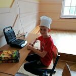 chłopiec w kucharskiej czapce przy gofrownicy