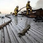 strażacy na spalonym dachu