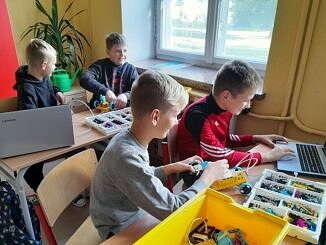 chłopcy przy komputerach i zestawach pomocy naukowych