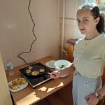 dziewczynka przy kuchence indukcyjnej z upieczonymi plackami