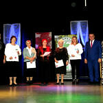 Nagradzane kobiety - przedstawicielki KGW - na scenie z wójtem i gośćmi