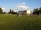Teren za Domem Ludowym w Gomulinie, gdzie powstanie kompleks boisk, na murawie chłopcy grają w piłkę