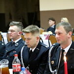 Strażacy w mundurach przy stołach wigilijnych