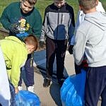 uczniowie zbierają śmieci do niebieskich worków
