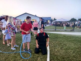 strażak i chłopiec przy strażackiej sikawce