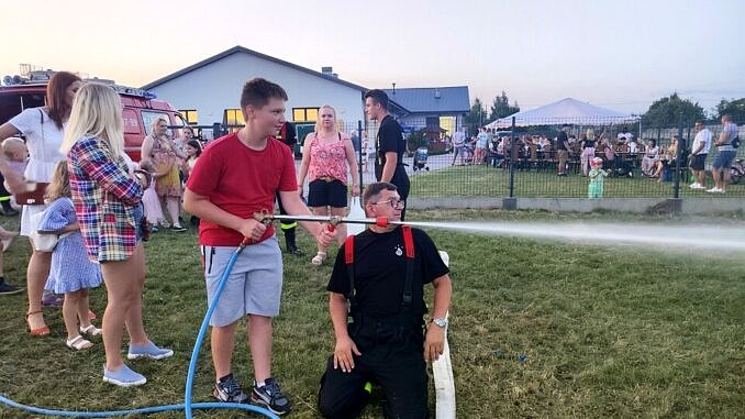 strażak i chłopiec przy strażackiej sikawce
