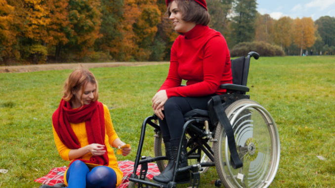 kobieta na wózku inwalidzkim, a druga obok