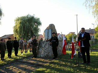 Uczniowie z klas mundurowych, harcerze i Tomasz Woźniak perzy obelisku ofiar