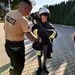 druh OSP prezentuje dzieciom strój strażacki