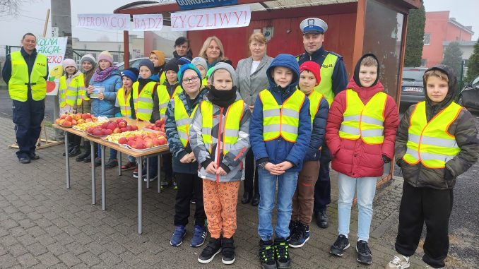 Dzieci z policjantami podczas akcji jabłko - cytryna