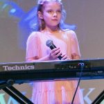 dziewczynka z mikrofonem prze keyboardzie