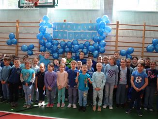 Dzieci ubrane na niebiesko na tle niebieskich balonów