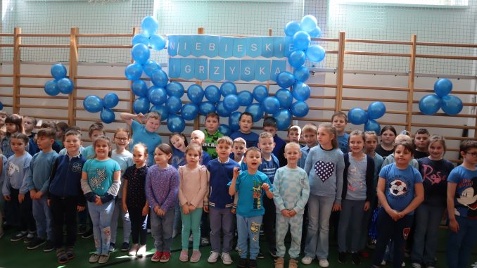 Dzieci ubrane na niebiesko na tle niebieskich balonów